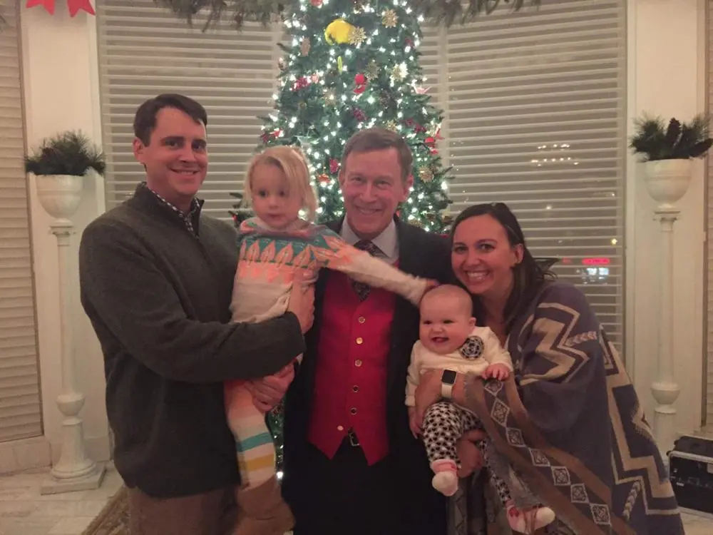 Val, her husband and daughters with Governor Hickenlooper by a holiday tree